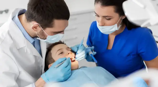 Chłopiec u dentysty. Czy do dentysty potrzebne jest skierowanie? Zależy od placówki, ale często nie.